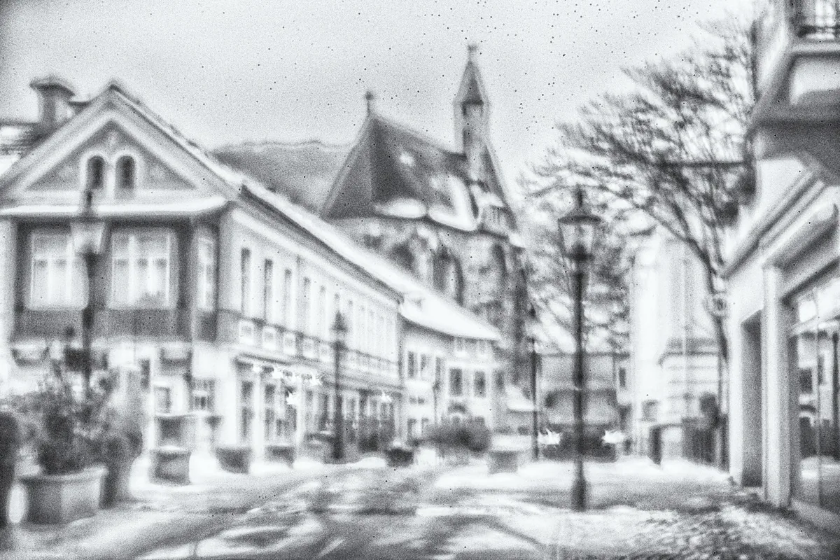 Häuserzeile mit Kirchturm und Straßenlaternen in zeichnerischer Bearbeitung