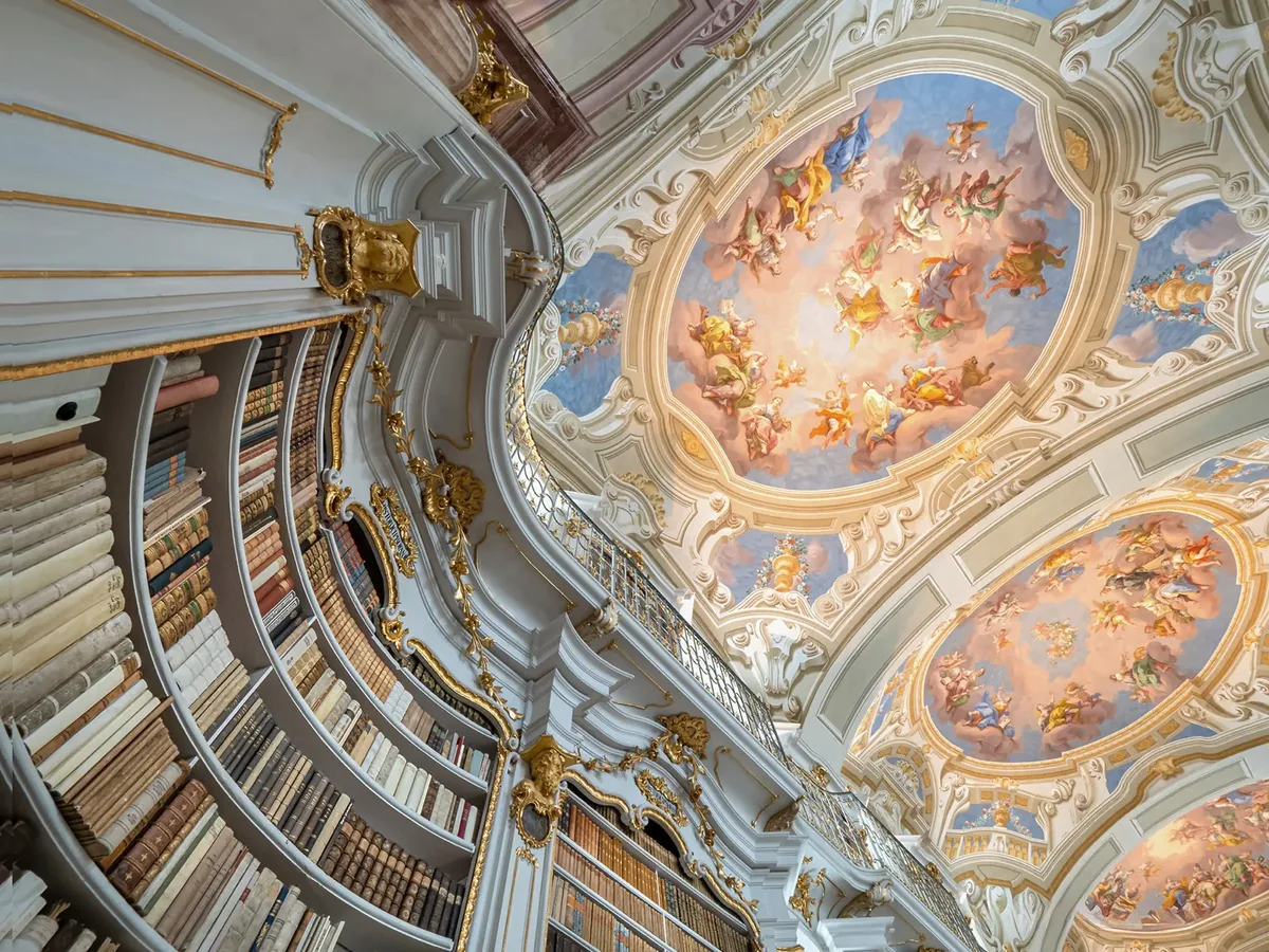 Barocker Bibliothekssaal mit Deckenfresko, von unten fotografiert